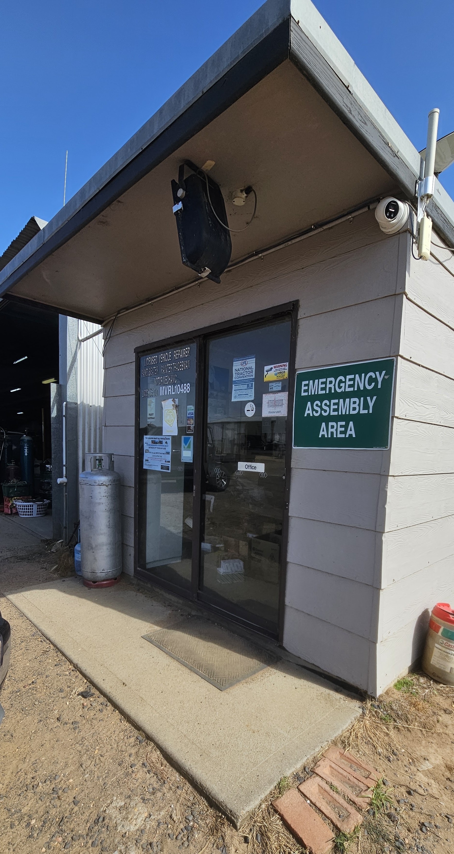 The office entrance at Jones' Panel Beating, with the licensed vehicle repairer signage on the glass