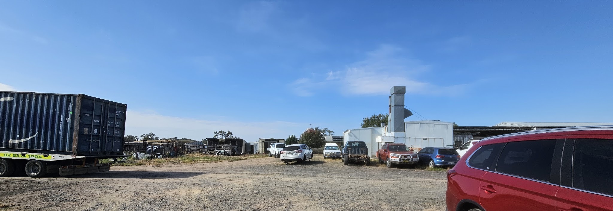 The Jones' Panel Beating yard at Gulgong, with the spray booth, vehicles in for repair and a tow trailer
